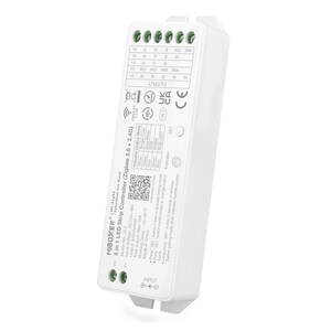 Puede incluir: Controlador de tira LED 5 en 1 blanco con tecnología Zigbee 3.0 + 2.4G. El dispositivo tiene una carcasa de plástico blanco con una etiqueta negra que incluye el nombre del producto, el número de modelo, la tensión de entrada, la salida, la salida total máxima, la temperatura de funcionamiento y un código QR. El dispositivo tiene un pequeño botón negro etiquetado como "SET" y un indicador LED verde.