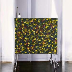 Puede incluir: Pintura abstracta con fondo negro y salpicaduras de pintura amarilla, roja y azul.