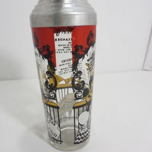 May include: A vintage glass cocktail shaker with a red, black and yellow design. The shaker features a cartoon illustration of a woman holding a glass of liquor. The shaker has a metal top and a glass bottom. The text on the shaker includes cocktail recipes, such as "Alexander", "Whiskey Sour", and "Bronx".