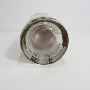 May include: Clear glass shot glass with a black and white design around the rim.