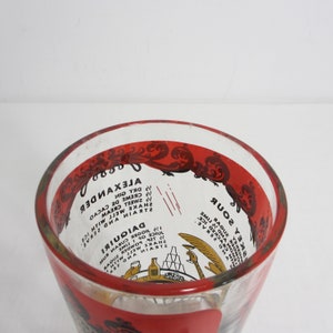 May include: A clear glass cocktail shaker with a red rim and a red and white design. The shaker has instructions for making a Daiquiri and an Alexander cocktail printed on the side.