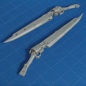 May include: Two grey, futuristic swords with detailed mechanical components. The blades have a serrated edge and a pointed tip. The handles resemble gun-like structures. The swords are displayed on a blue grid surface.