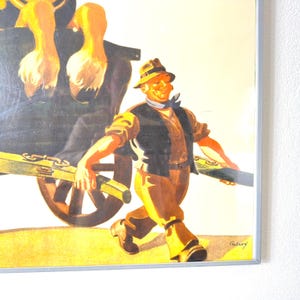 May include: Framed vintage print featuring a smiling man in a hat and vest pulling a cart with a load of what appears to be ducks. The artwork has a warm color palette with shades of yellow, brown, and black.