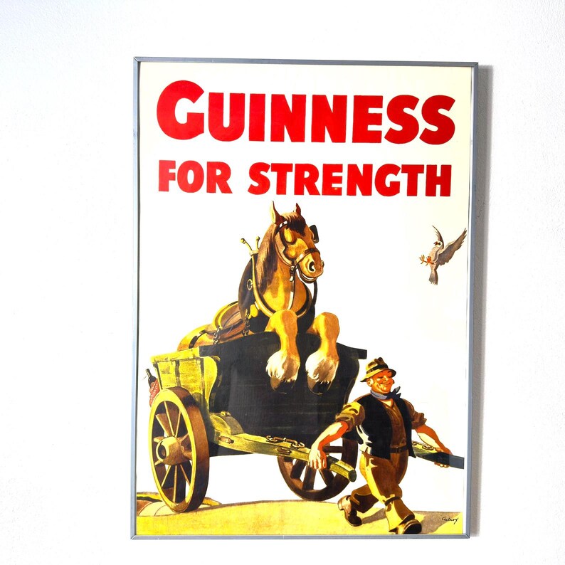 May include: Vintage Guinness advertisement poster. The poster features a horse-drawn cart with the text "GUINNESS FOR STRENGTH" in red. A man walks alongside the cart, and a bird flies in the background. The poster has a white background.