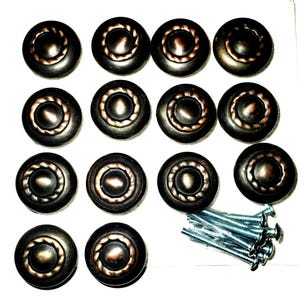 Puede incluir: Un juego de dieciséis tiradores de armario de color bronce, con un diseño de cuerda alrededor del borde y un detalle circular central. Incluye un juego de tornillos plateados para la instalación. Ideal para armarios de cocina o baño.