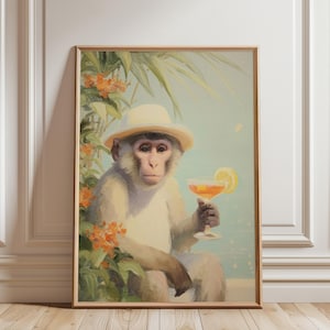 May include: A framed art print featuring a monkey wearing a hat and holding a cocktail with a lemon slice. The monkey is surrounded by foliage and orange flowers, set against a light blue background. The artwork has a vintage, whimsical style.