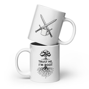 Könnte beinhalten: Eine weiße Keramiktasse mit einer Schwarzweißillustration von gekreuzten Schwertern und einer Kaffeetasse. Die Tasse ist auf einer anderen weißen Keramiktasse mit einer Schwarzweißillustration eines Baumes mit Wurzeln und dem Text "Trust me, I'm root" gestapelt.