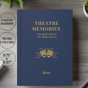 May include: A dark blue hardback journal with gold text reading THEATRE MEMORIES A Keepsake Journal For Theatre Lovers, a comedy and tragedy mask graphic, and the name Kyra. The cover dimensions are 14.5 cm by 20.5 cm.