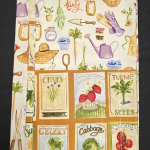May include: A fabric garden-themed journal with a cream background and colorful illustrations of gardening tools, vegetables, and seed packets. The journal features the word "tasty" in script and images of chives, strawberries, and tomatoes.
