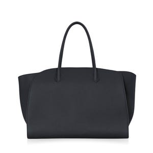 Puede incluir: Un bolso tote negro liso con superficie texturizada, que cuenta con dos asas superiores finas y redondeadas unidas al cuerpo principal. El bolso tiene una base ancha y estructurada, con paneles laterales ligeramente acampanados hacia afuera.