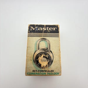 May include: A rectangular cardboard box for a Master key-controlled combination padlock. The box features a vintage graphic of a round padlock with a silver shackle and a black dial. The text reads Master, KEY-CONTROLLED, and COMBINATION PADLOCK.
