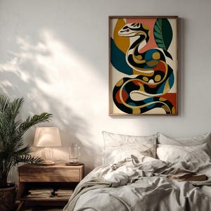 Puede incluir: Una impresión de arte mural rectangular que presenta una serpiente estilizada y sinuosa en una paleta de negro, crema, amarillo mostaza, azul profundo y rojo terracota. La serpiente está rodeada de formas de hojas abstractas en verde oscuro y azul verdoso.