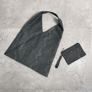 Può includere: Una borsa tote di colore grigio scuro con motivo a pelle di serpente e una pochette abbinata più piccola. La borsa tote ha una parte superiore larga e aperta e un'unica tracolla.