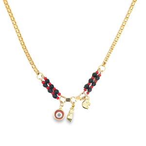 May include: Gold-toned necklace featuring a chain and beaded accents. The necklace has red and black beads, with charms including an eye, a fist, and a heart. The necklace is designed with a delicate and intricate style.