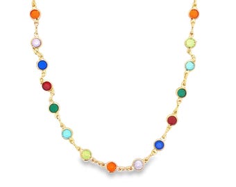 May include: A gold-colored necklace featuring a series of colorful, round gemstones. The gemstones are arranged in a repeating pattern of red, orange, yellow, green, blue, and purple. The necklace is displayed against a white background.