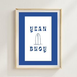 May include: A framed print with a blue background and white text that says "Yeah Buoy" with a stylized surfboard graphic in the middle.