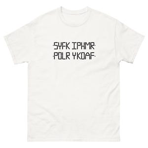 Peut inclure: Un t-shirt blanc à col rond et manches courtes. Le t-shirt présente un texte noir en police pixélisée : "SYFK IPHMR. POLR YKDAF."