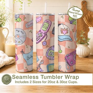 May include: A cylindrical tumbler with a straw featuring a repeating Y2K-inspired pattern on a peach and white checkered background. The design includes illustrations of a pink flip phone, a CD, a digital pet, a camera, and a cap with a heart flame.