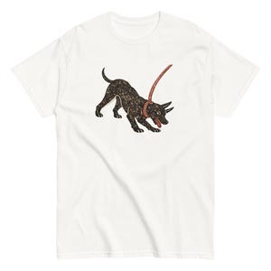 May include: White t-shirt with a graphic of a black dog on a leash. The dog is in a playful stance, tongue out. The leash and collar are red. The design has a textured appearance.