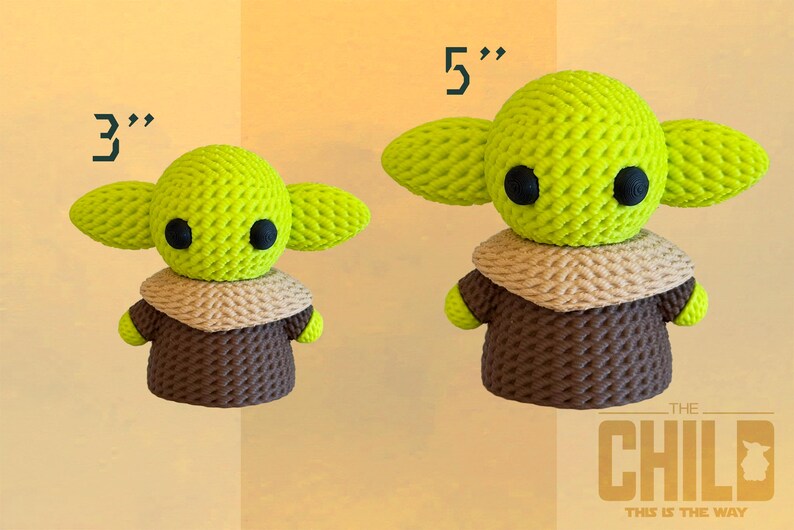 May include: Two crocheted figures of The Child, one 3 inches tall and the other 5 inches tall. The figures have large green ears, black eyes, and wear brown robes with tan collars. The text "THE CHILD" and "THIS IS THE WAY" is in the lower right corner.