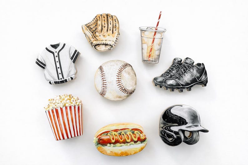 May include: A collection of baseball-themed items including a white jersey, a tan leather glove, a clear cup with a red-striped straw, a white baseball, black cleats, a red and white striped popcorn container, a hot dog, and a black helmet.