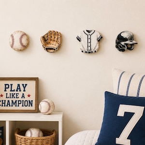 May include: Four wall-mounted baseball-themed decorations including a baseball, a glove, a jersey, and a helmet. Below, a framed sign reads PLAY LIKE A CHAMPION, accompanied by a baseball, a basket of baseballs, and a blue pillow with a white number 7.