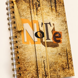 Pode incluir: Um caderno de espiral com uma capa texturizada de cor ferrugem desgastada, apresentando a palavra "Note" numa fonte estilo colagem. O caderno inclui uma banda elástica de fecho vertical amarela e uma borla amarela a condizer na espiral.