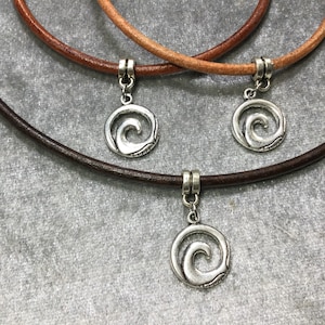 May include: Three leather cord necklaces with silver wave pendant charms. The necklaces are brown, tan, and dark brown.