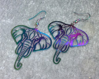May include: A pair of iridescent silver earrings shaped like elephants. The earrings are made of metal and have a detailed design.