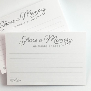 May include: Two white cards with the text "Share a Memory OR WORDS OF LOVE" in elegant black script. The cards have lined spaces for writing and the words "With Love" at the bottom. Ideal for guest books or memory sharing.