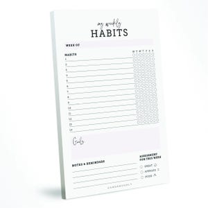 May include: A white notepad with the text "my weekly HABITS" at the top. The notepad includes sections for tracking habits, goals, notes, and a weekly assessment. The design is minimalist with black text and a simple layout.