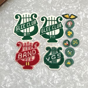 May include: A white ceramic mug with a black handle and the text "But First, Coffee" in a bold, black font. The mug is set against a neutral background, highlighting its simple design.