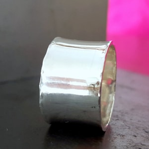 sterling silver ring, about 14mm wide, with a smooth texture, and a shiny finish. A comfortable statement ring loved equally by women and men.