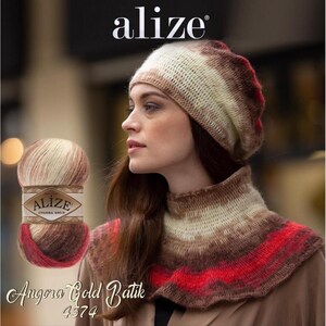 May include: A woman wearing a knitted hat and cowl in shades of brown, cream, and red. A ball of Alize Angora Gold Batik yarn is visible. The yarn label and the Alize logo are also visible.