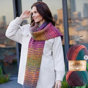 May include: A woman wearing a colorful, striped scarf with shades of purple, pink, yellow, and blue. The scarf is wrapped around her neck and shoulders. A ball of Alize yarn in matching colors is visible in the image.