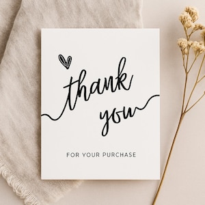 May include: A white card with black text that says "thank you" with a small heart above the word "thank". Below the text is "for your purchase".
