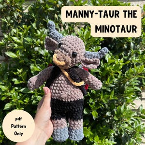 Könnte beinhalten: Handgefertigte Minotaurus-Puppe aus Häkelarbeit in Grau-, Braun-, Schwarz- und Blautönen. Die Puppe hat Hörner, einen Rucksack und einen gelben Riemen. Der Text auf dem Bild lautet "Manny-Taur the Minotaur" und "pdf Pattern Only".