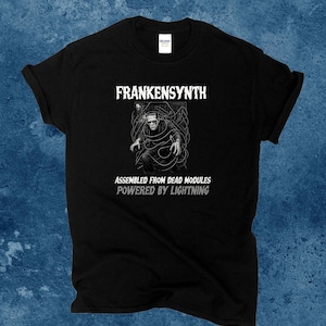 May include: Black t-shirt with the text "Frankensynth" above a graphic of Frankenstein's monster. Below the graphic, the text reads "Assembled from dead modules powered by lightning."