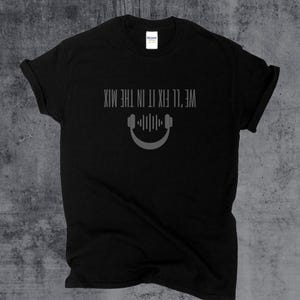 May include: Black t-shirt with the text "WE'LL FIX IT IN THE MIX" above a graphic of headphones and sound waves. The shirt is made of a soft material and has a crew neck.