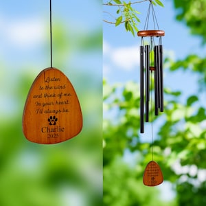 May include: A wooden wind chime with black metal tubes and a wooden top. The wooden piece at the bottom has the text "Listen to the wind and think of me. In your heart. I'll always be. Charlie 2025" and a paw print.
