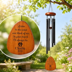 Peut inclure: Un carillon éolien composé de tubes métalliques noirs suspendus à un support circulaire en bois. Un pendentif en bois en forme de goutte porte l'inscription gravée : Listen to the wind and think of me. In your heart. I'll always be. Charlie 2025.