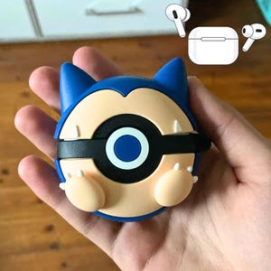 Könnte beinhalten: Eine blaue und weiße Handyhülle mit einem Pokemon-Charakter, einem schwarzen Auge und einem weißen Kreis in der Mitte. Die Hülle ist aus Silikon und hat ein 3D-Design.
