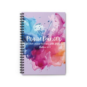 May include: Spiral-bound notebook with a cover featuring the words "Praise Dancer" in white script over a colorful watercolor design. The design includes splashes of blue, pink, and orange hues, with the text "Let them praise his name with Dancing" and "Psalms 149:3".