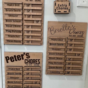 May include: Three wooden chore charts with sliding check marks for kids. The charts are labeled "Parker's Chores", "Peter's Chores", and "Brielle's Chores". Each chart has a list of chores, including "Make Bed", "Brush Teeth", "Shower", "Book School", "Read 20min", "Play Outside", "Trash Out", "Clean Room", and "Clean Bathroom".