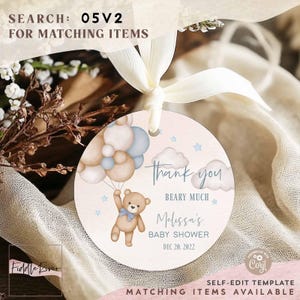 Puede incluir: Una etiqueta redonda rosa y blanca de agradecimiento con un oso de peluche marrón que sostiene globos azules y blancos. La etiqueta dice "Gracias Beary Much Melissa's Baby Shower Dec 20, 2022".