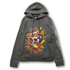 May include: Dark gray hooded sweatshirt featuring a skull graphic engulfed in flames. The design includes red, yellow, and orange hues. The sweatshirt has a front pocket and a drawstring hood. Text is visible on the sleeve and upper chest.