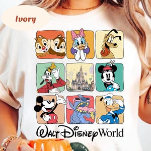 May include: Ivory-colored t-shirt featuring a grid of Disney characters including Chip and Dale, Daisy Duck, Goofy, Mickey Mouse, Minnie Mouse, Stitch, and Donald Duck. The words "Walt Disney World" are printed below the grid.