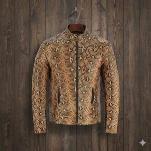 Puede incluir: Chaqueta marrón y beige con estampado de piel de serpiente, cuello alzado y cremallera completa. La chaqueta tiene dos bolsillos con cremallera y está colgada de una percha de madera sobre un fondo de madera.