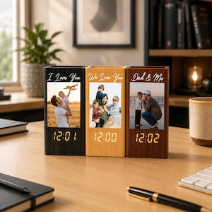 May include: Three rectangular wooden digital clocks in black, light wood, and dark wood finishes. Each clock features a vertical photo print and white text: I Love You, We Love You, and Dad & Me. The digital displays show times in yellow light.