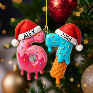 May include: Two Christmas ornaments shaped like the numbers 6 and 7. The number 6 is pink with sprinkles and the name "ALEX" on a Santa hat. The number 7 is blue with sprinkles and the year "2025" on a Santa hat, with an ice cream cone base.
